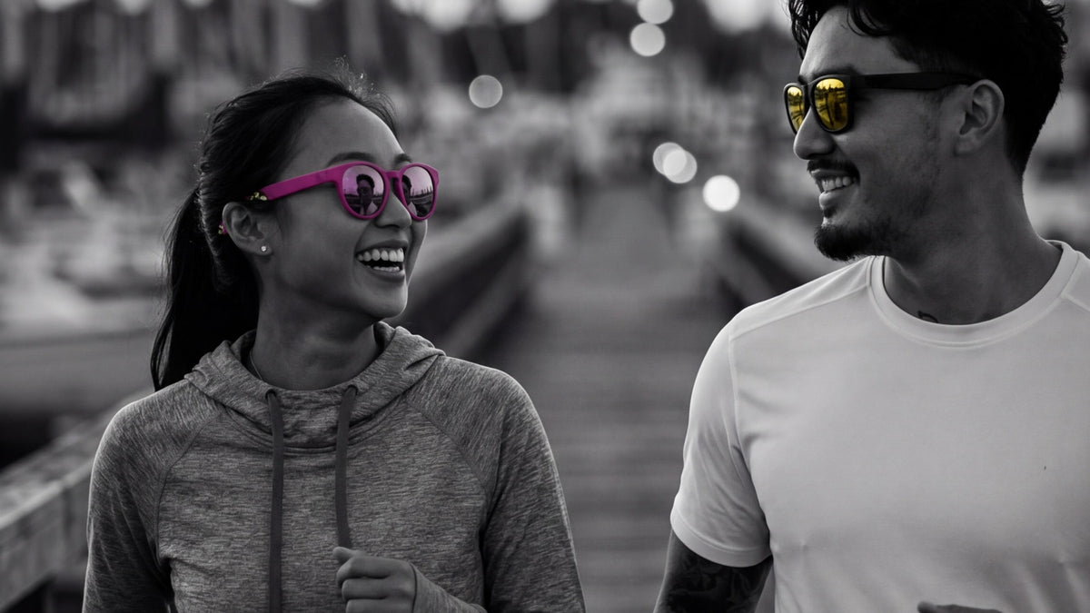 Two runners wearing performance sunglasses on a marina route in humid urban conditions