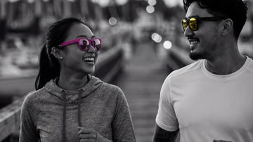 Two runners wearing performance sunglasses on a marina route in humid urban conditions