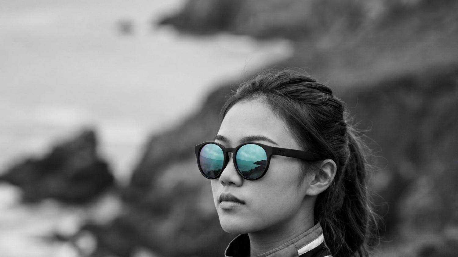 Woman wearing 2nu sunglasses with reflective lenses near the coast, showing lens tint and glare control for outdoor use
