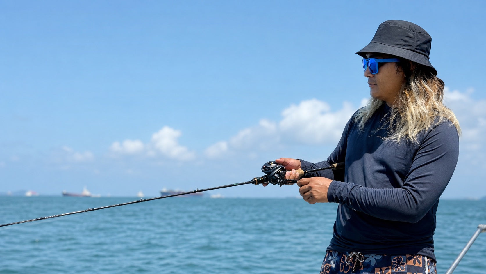 Angler wearing blue mirrored 2nu sunglasses while fishing on open water for the Fishing and Everyday sunglasses guide.